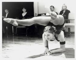 A young woman demonstrates flexibility and strength in a yoga competition.