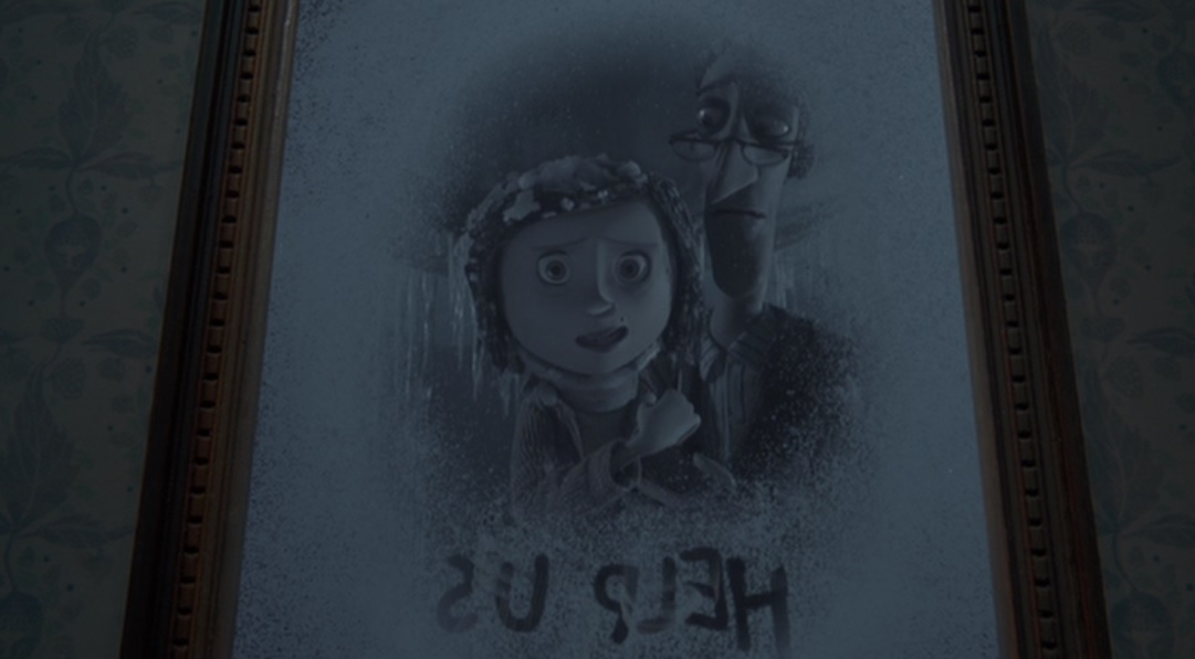 A vision in a mirror of Coraline's parents trapped in the snow globe