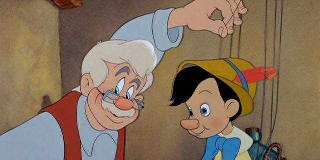 Geppetto holding Pinocchio with strings